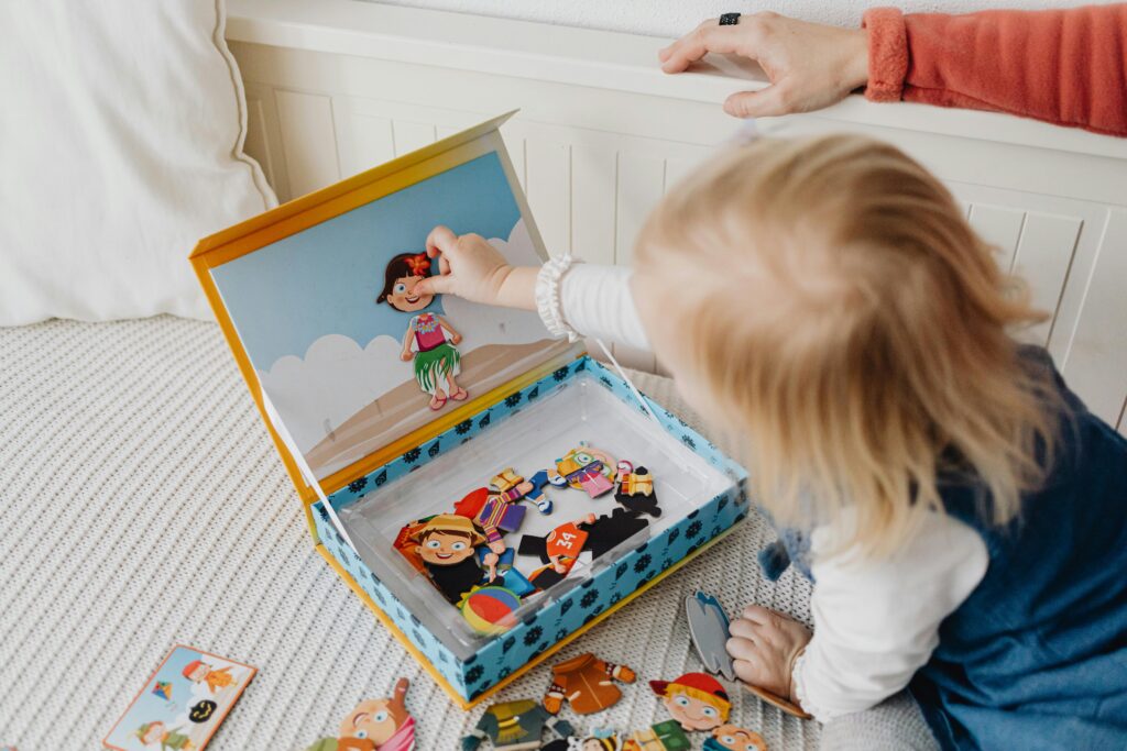 Young child playing with puzzles on a bed indoors, fostering creativity and learning.